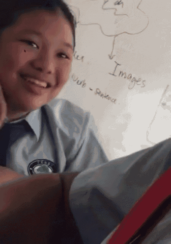 a girl is smiling in front of a white board with the word images written on it