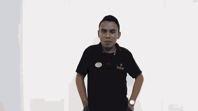 a man wearing a black polo shirt with a name tag that says carlos