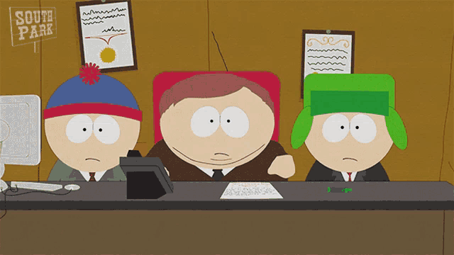 three south park characters sit at a desk in front of a sign that reads south park