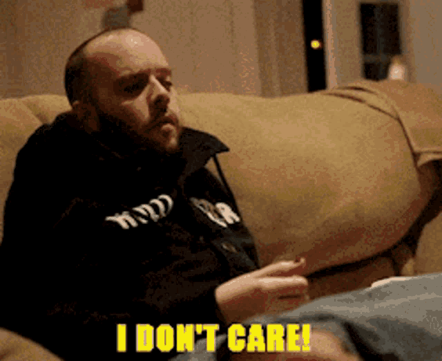 a man sitting on a couch with the words " i don 't care " above him