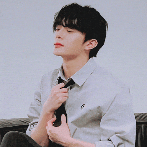 a man in a white shirt with the letter r on the collar