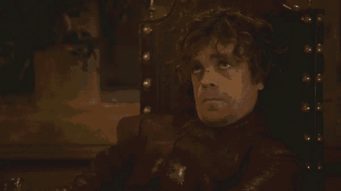 a man is sitting in a chair holding a knife and making a face .