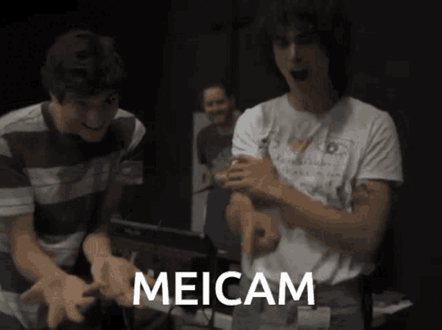 two men are playing a video game and the word meicam is on the bottom right