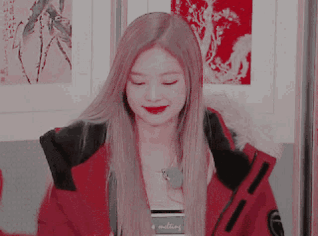 a girl in a red jacket is smiling and holding a credit card