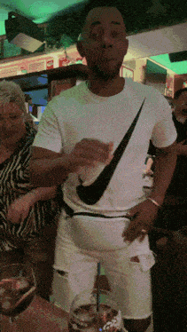 a man wearing a nike t-shirt is holding a drink in his hand