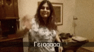 a woman is dancing in a room with a sign that says gelaaaa