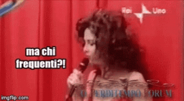 a woman is singing into a microphone and says ma chi frequenti ?