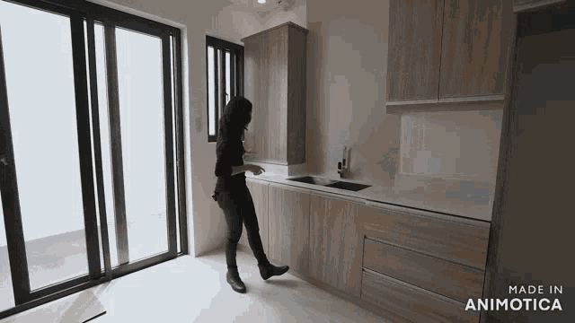 a woman is standing in a kitchen with the words made in animatica on the bottom right