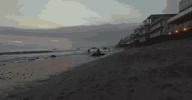 a beach with a row of houses along the shore