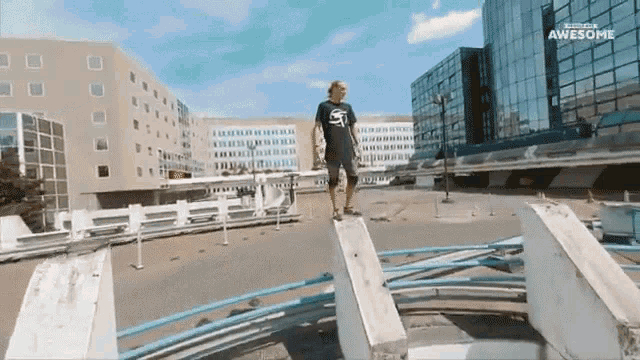 a man in a t-shirt that says awesome stands on a concrete block