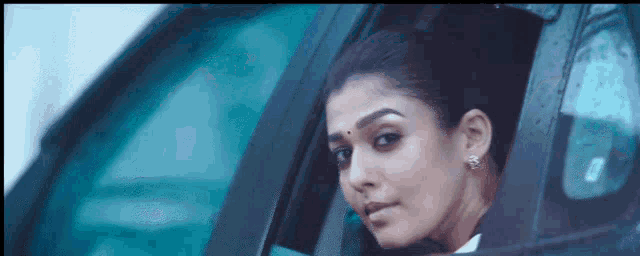 a woman is looking out of a car window