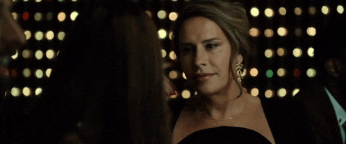 a woman in a black dress with gold earrings
