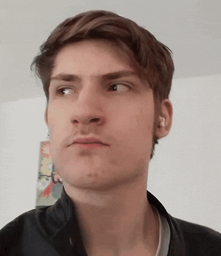 a close up of a young man 's face with a serious look on his face