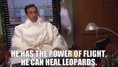 a man in a white robe is sitting at a desk in front of a computer with a quote from the office .