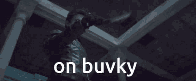a man in a leather jacket is holding a knife with the words on buvky written below him