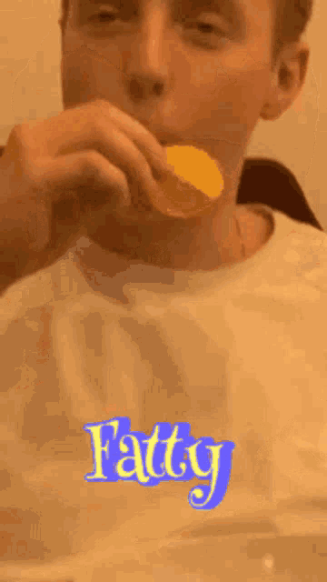 a man is eating a slice of cheese with the word fatty written on his shirt