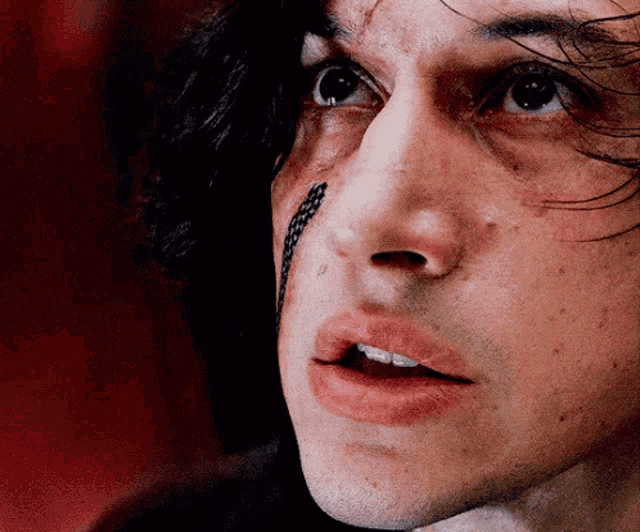 a close up of a man 's face with a snake tattoo on his face