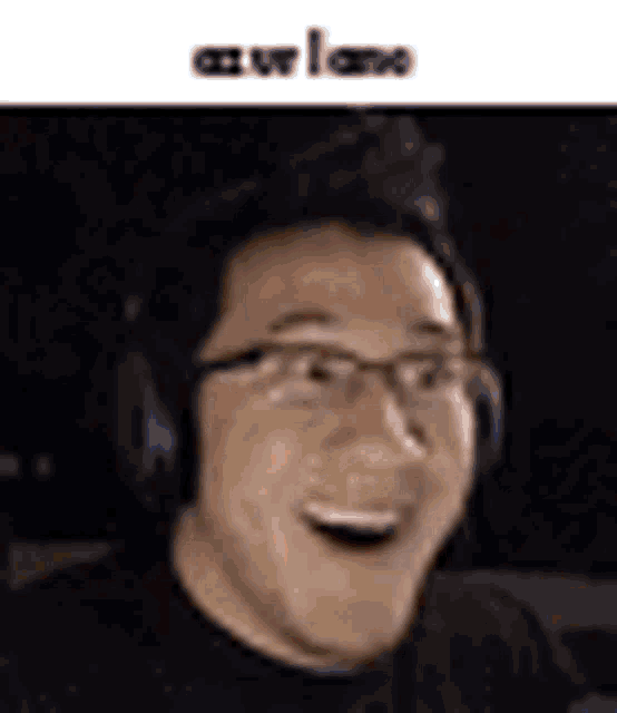 a man wearing glasses and headphones is smiling .