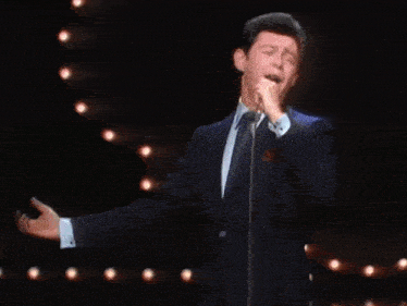 a man in a suit and tie has his arms outstretched