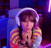 a woman wearing headphones sitting in front of a microphone