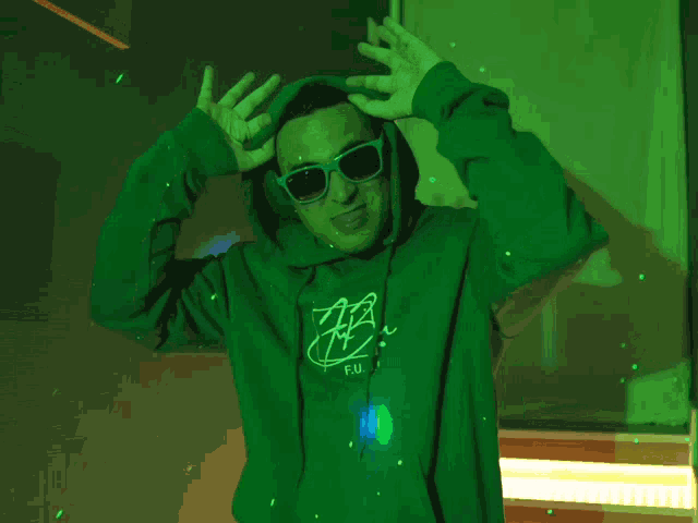 a man wearing a green hoodie that says fb