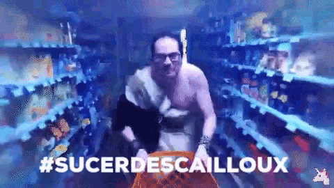 a man without a shirt is pushing a shopping cart in a store aisle .