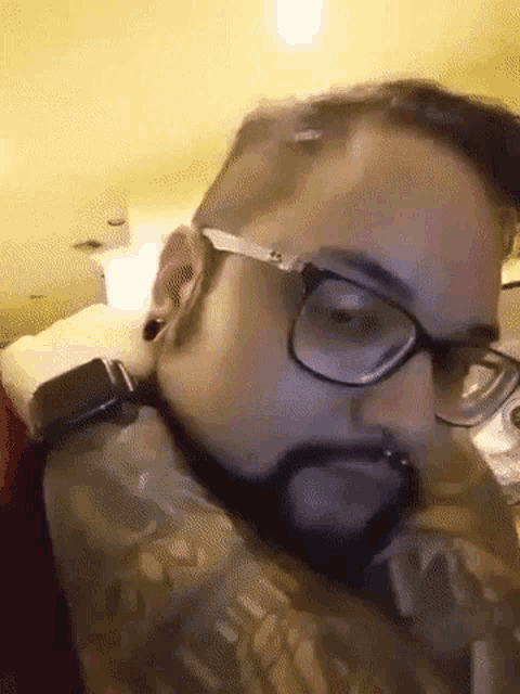 a man with a beard wearing glasses and a watch