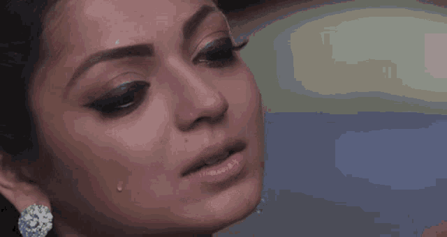a close up of a woman 's face with tears coming out of her eyes .