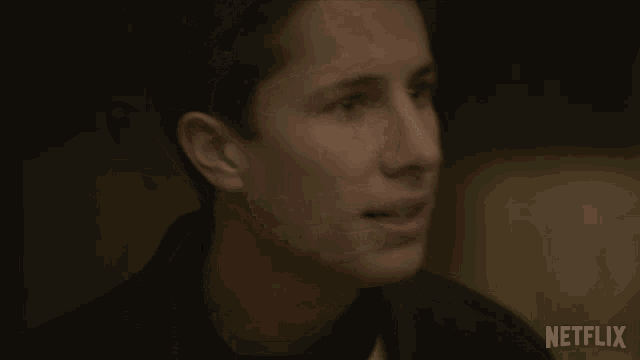a close up of a man 's face with a netflix logo on the bottom right