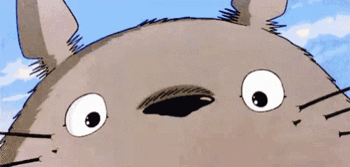 a close up of a cartoon character 's face with a big smile and a blue sky in the background .