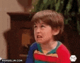 a young boy is making a funny face while sitting in front of a piano .