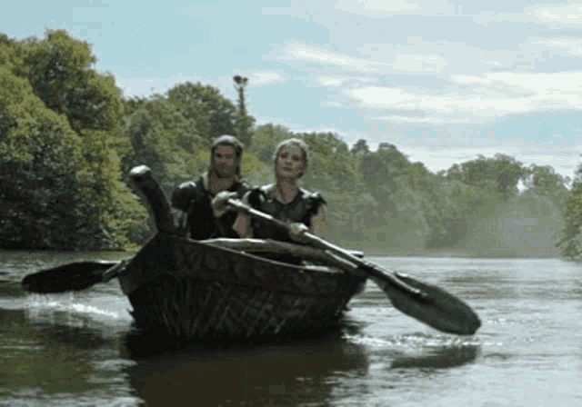 a man and a woman in a boat on a river
