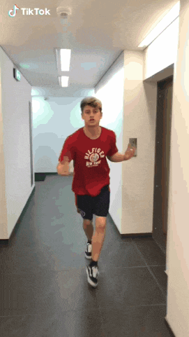 a man wearing a red t-shirt that says hilfiger on it
