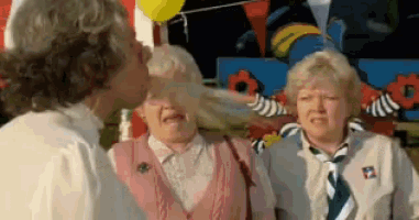 a man is blowing a balloon into a woman 's eye