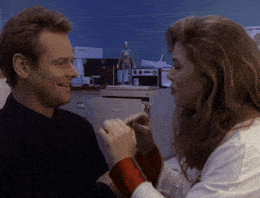 a man and a woman are holding hands and the woman is wearing a white lab coat
