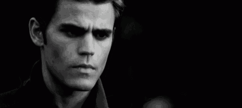 a close up of a man 's face in a black and white photo with his eyes closed .