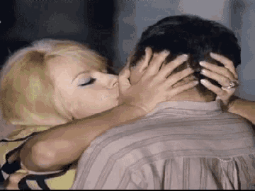 a woman with a ring on her finger is kissing a man