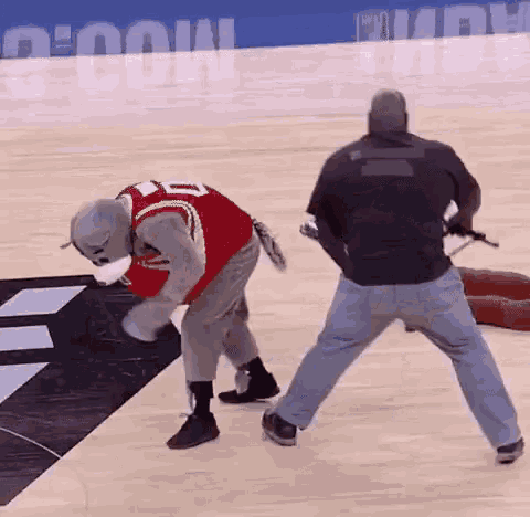 a man in a mascot costume is standing on a basketball court .