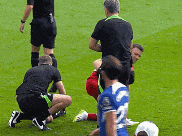 a soccer player with the number 22 on his jersey is kneeling on the field
