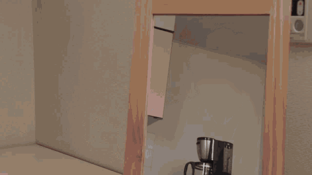 a corner of a room with a wooden frame and a white wall