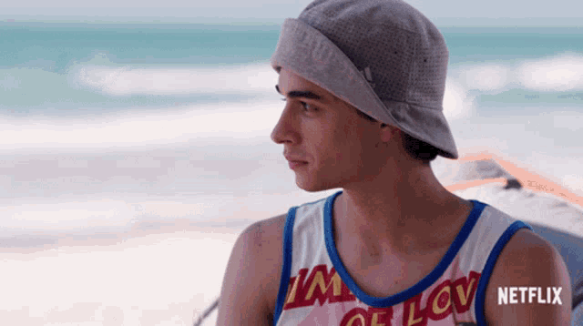 a young man wearing a hat and a tank top that says netflix on it
