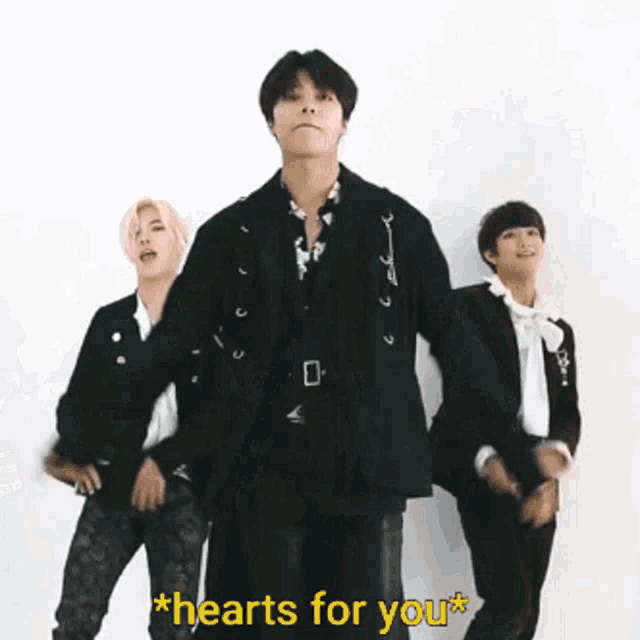 a group of men in suits are dancing with the words hearts for you behind them