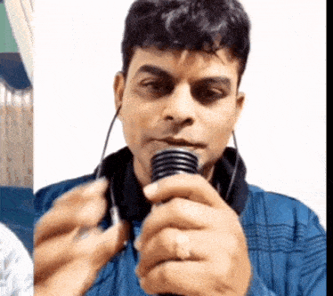 a man in a blue shirt is holding a microphone