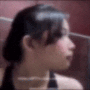 a close up of a woman 's face with a ponytail .