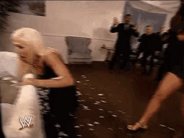 two women are having a pillow fight with a w logo