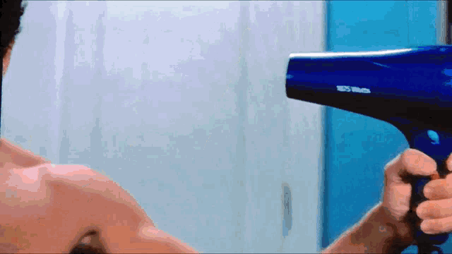 a man is holding a blue hair dryer that says nsf on it