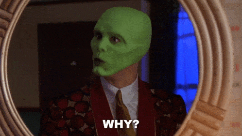 a man with a green mask is looking at himself in a mirror and says " why "