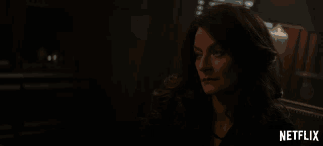 a woman in a dark room with netflix written on the bottom
