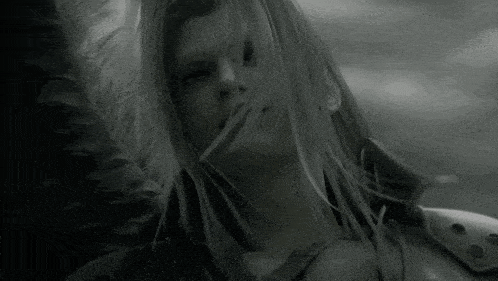 a black and white photo of a woman 's face with her hair blowing in the wind