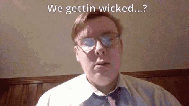a man wearing glasses and a white shirt says we gettin wicked
